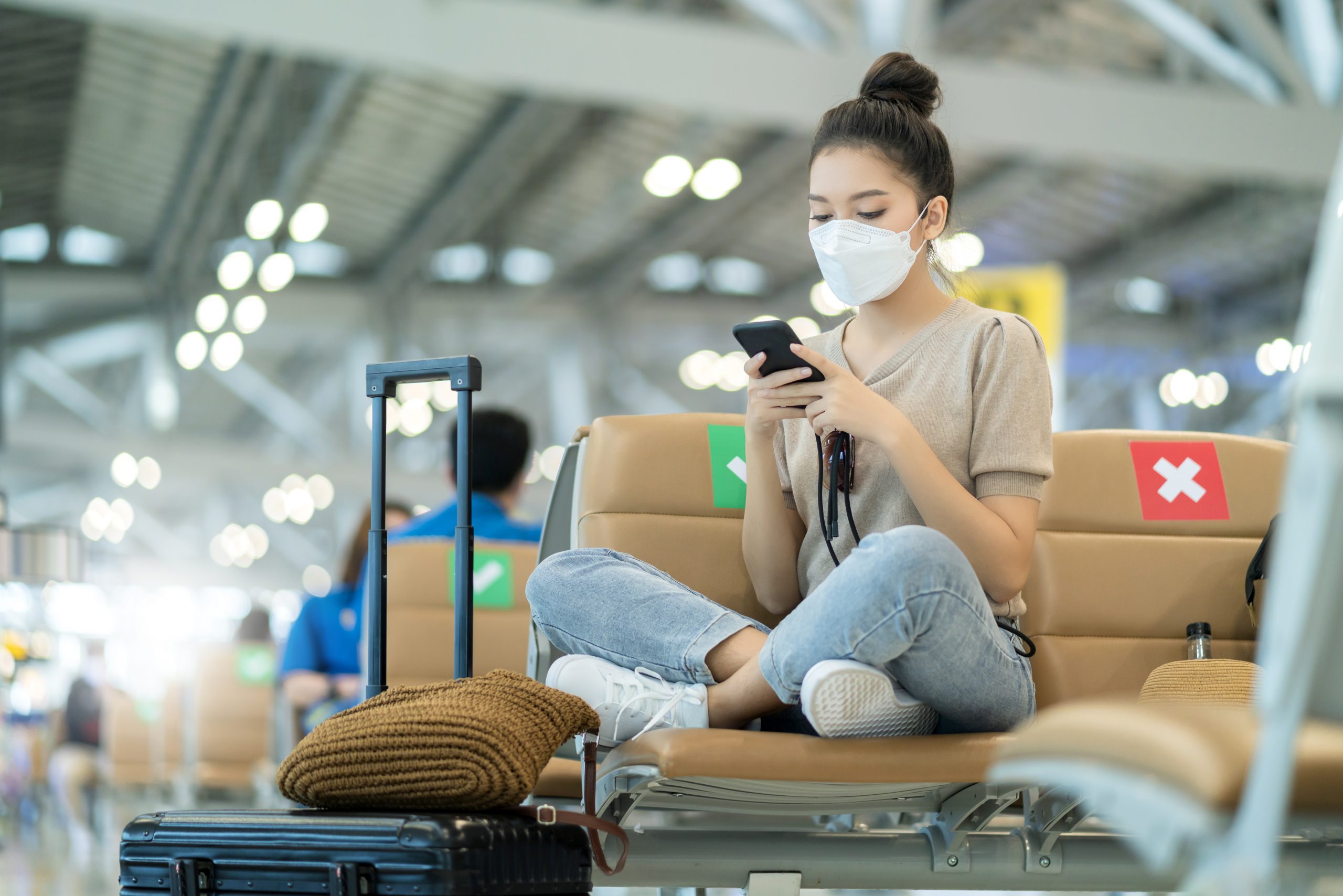Asian woman using her phone at the airport.