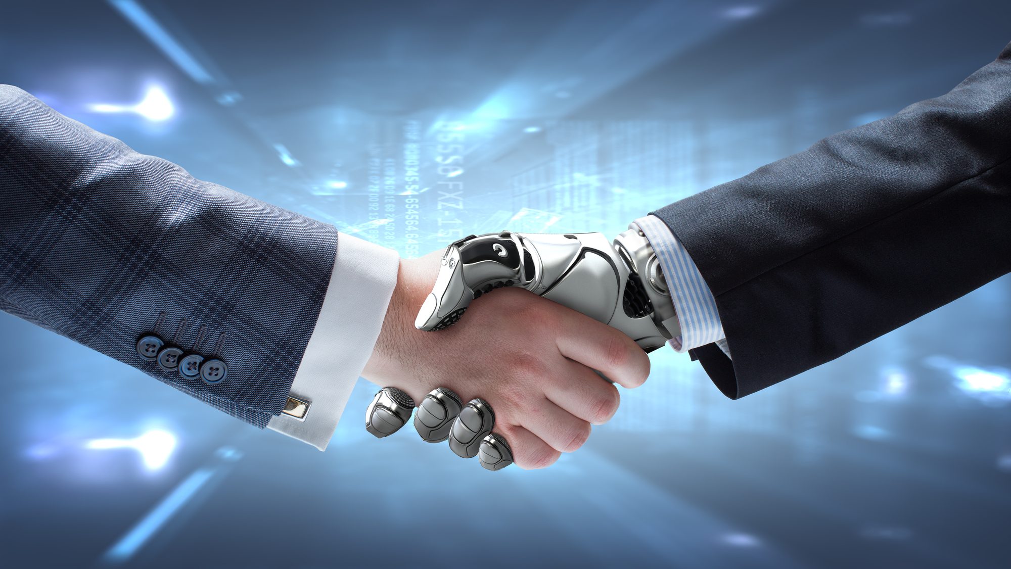 Person's hand and a robot's hand shaking hands.
