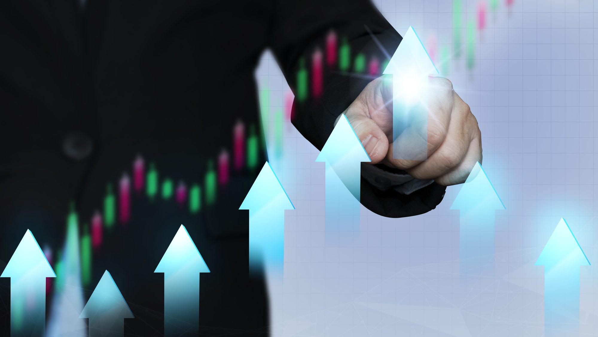 Businessman pointing an upward arrow on a stock graph.