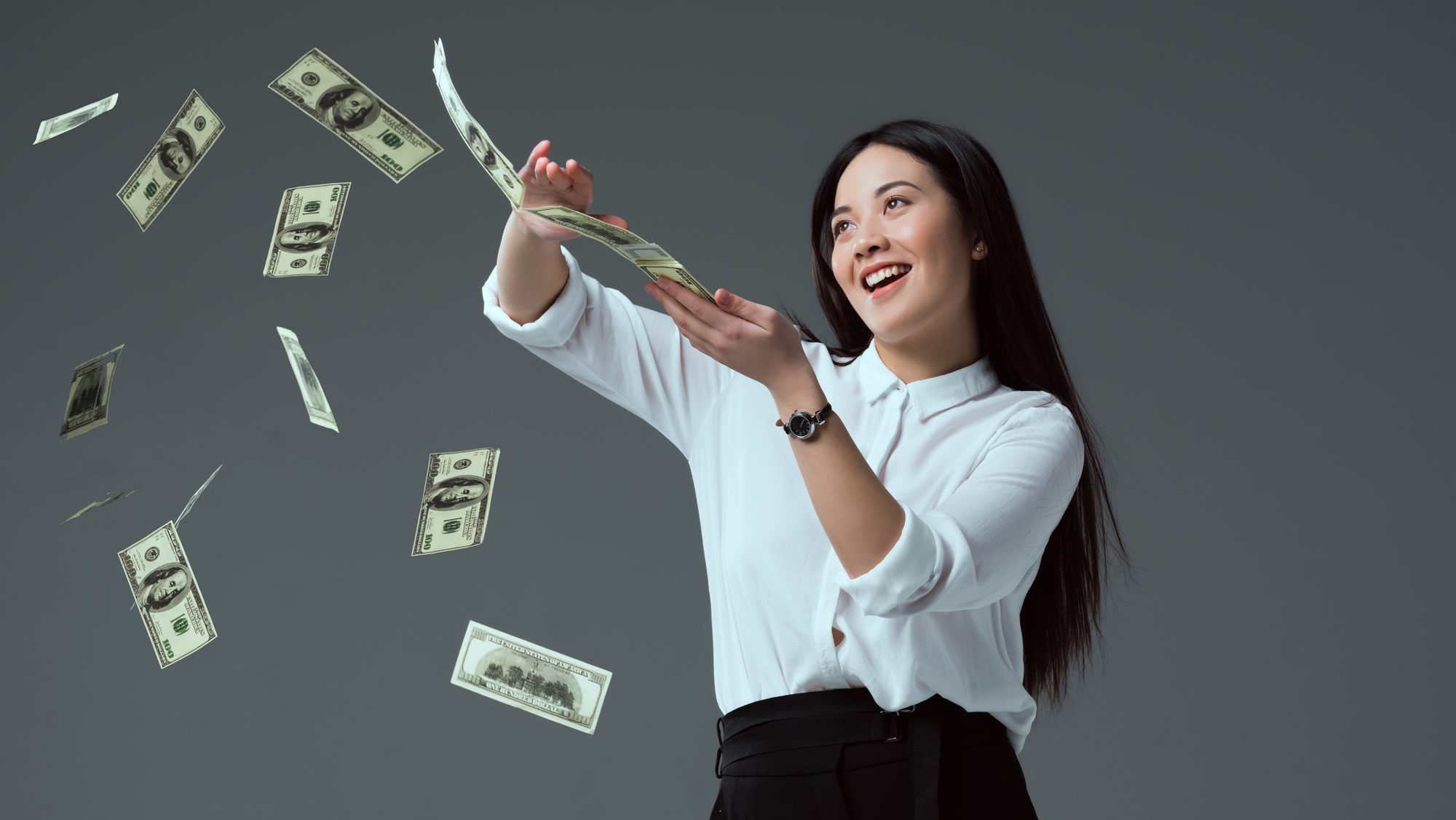 A woman smiling and money in the air.
