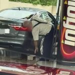 Man raises his SG-registered Jaguar car with brick at JB petrol station, possibly to pump in more petrol